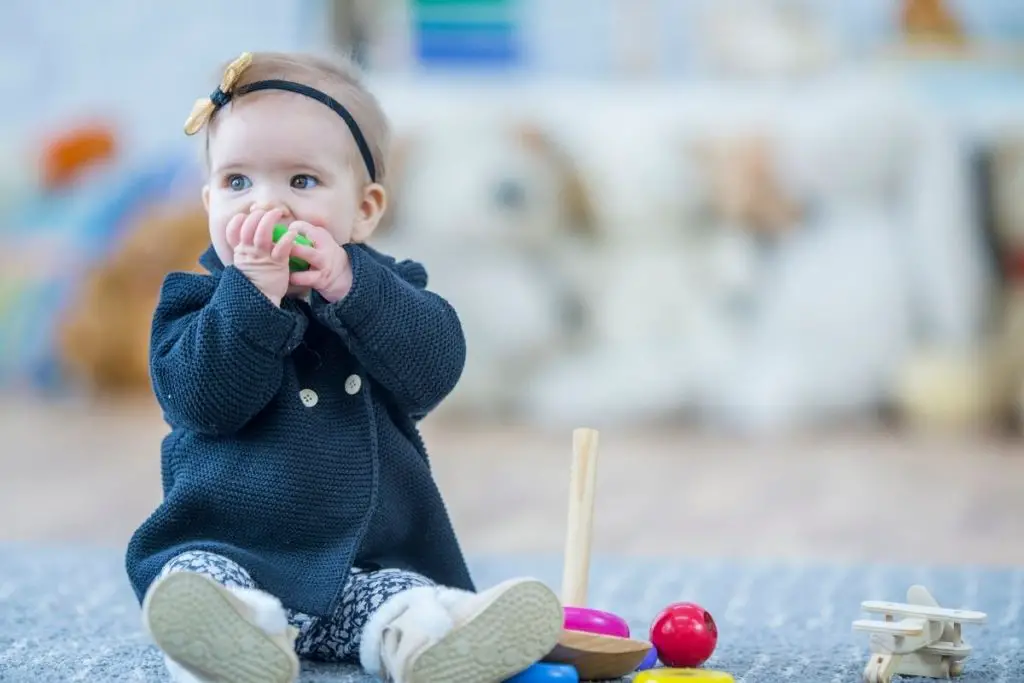 A baby chewing on a toy, showing how babies will put anything into their mouths during the teething phase. 